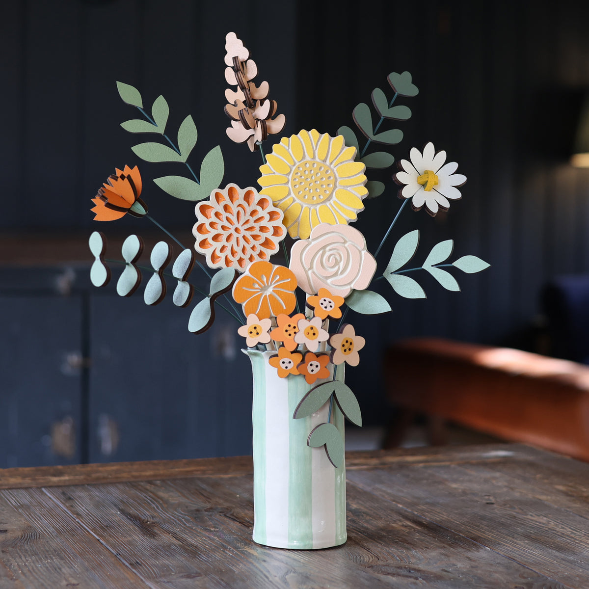 Statement Blooms in Satsuma, eight wooden blooms and five foliage sprigs in warm orange, styled in a room
