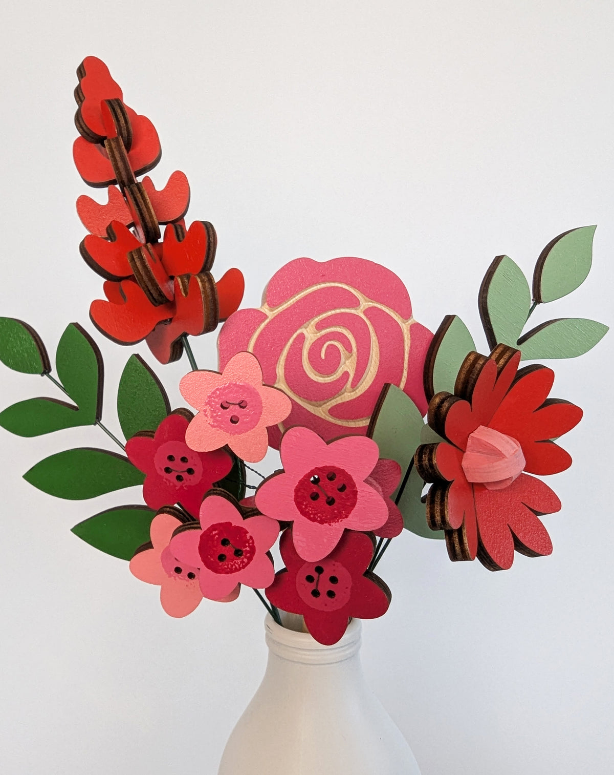Signature Blooms in Framboise, a close crop of the wooden blooms in red, fuchsia and pink
