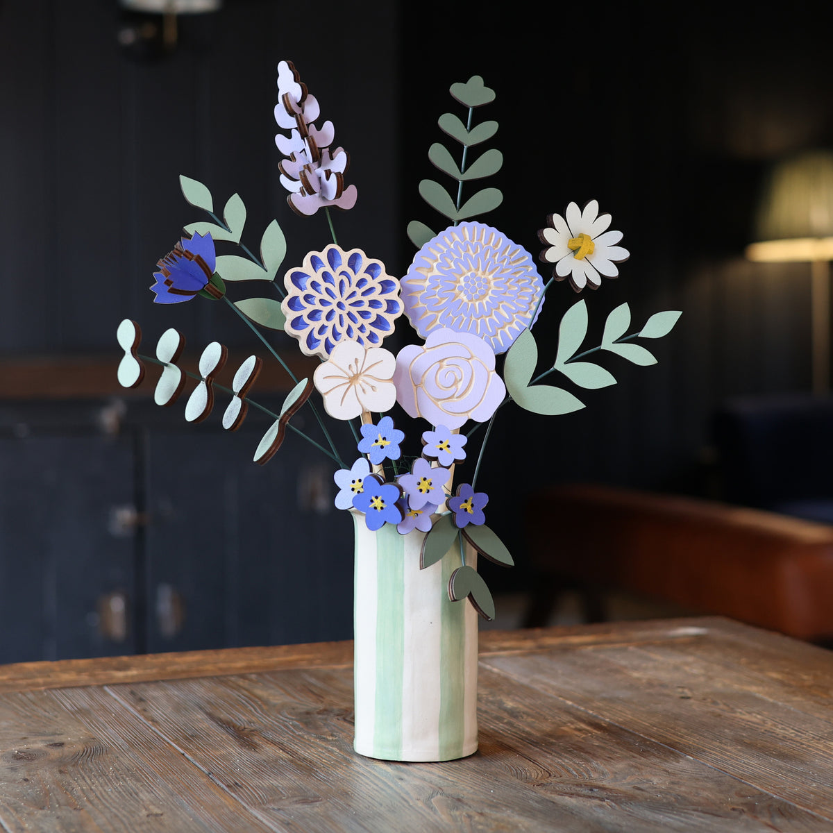 Statement Blooms in Parma Violet, eight wooden blooms and five foliage sprigs in violet and lilac, styled in a room 