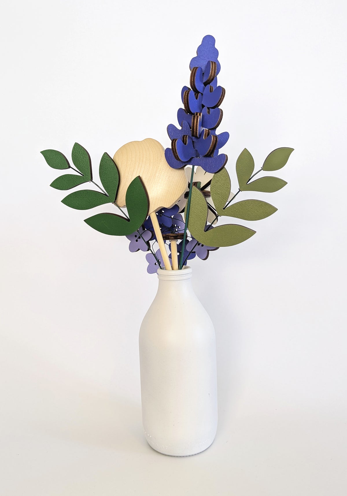 Signature Blooms in Parma Violet, four wooden blooms and two foliage stems in violet and lilac, seen from behind 