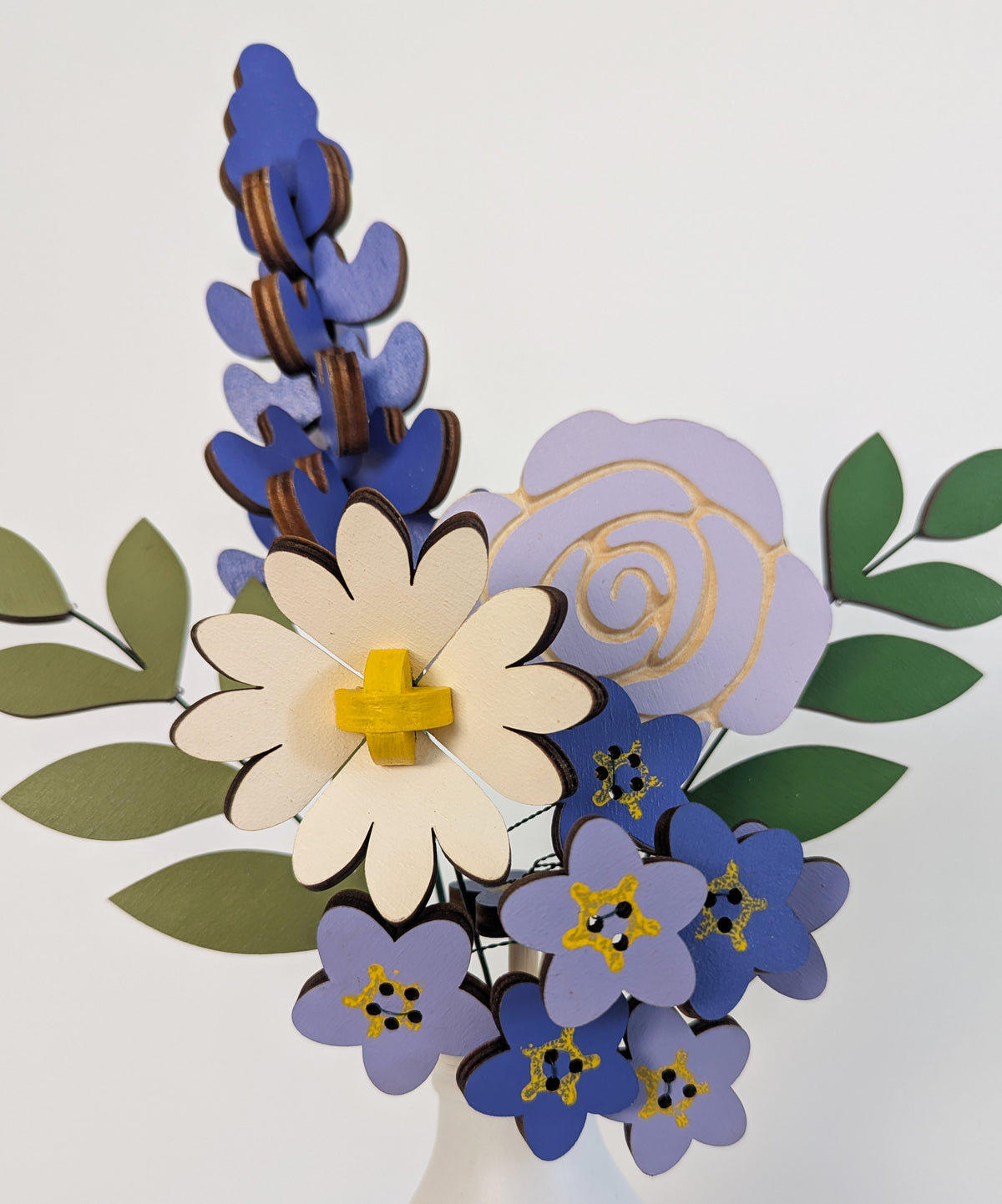 Signature Blooms in Parma Violet, four wooden blooms and two foliage stems in violet and lilac, close up 