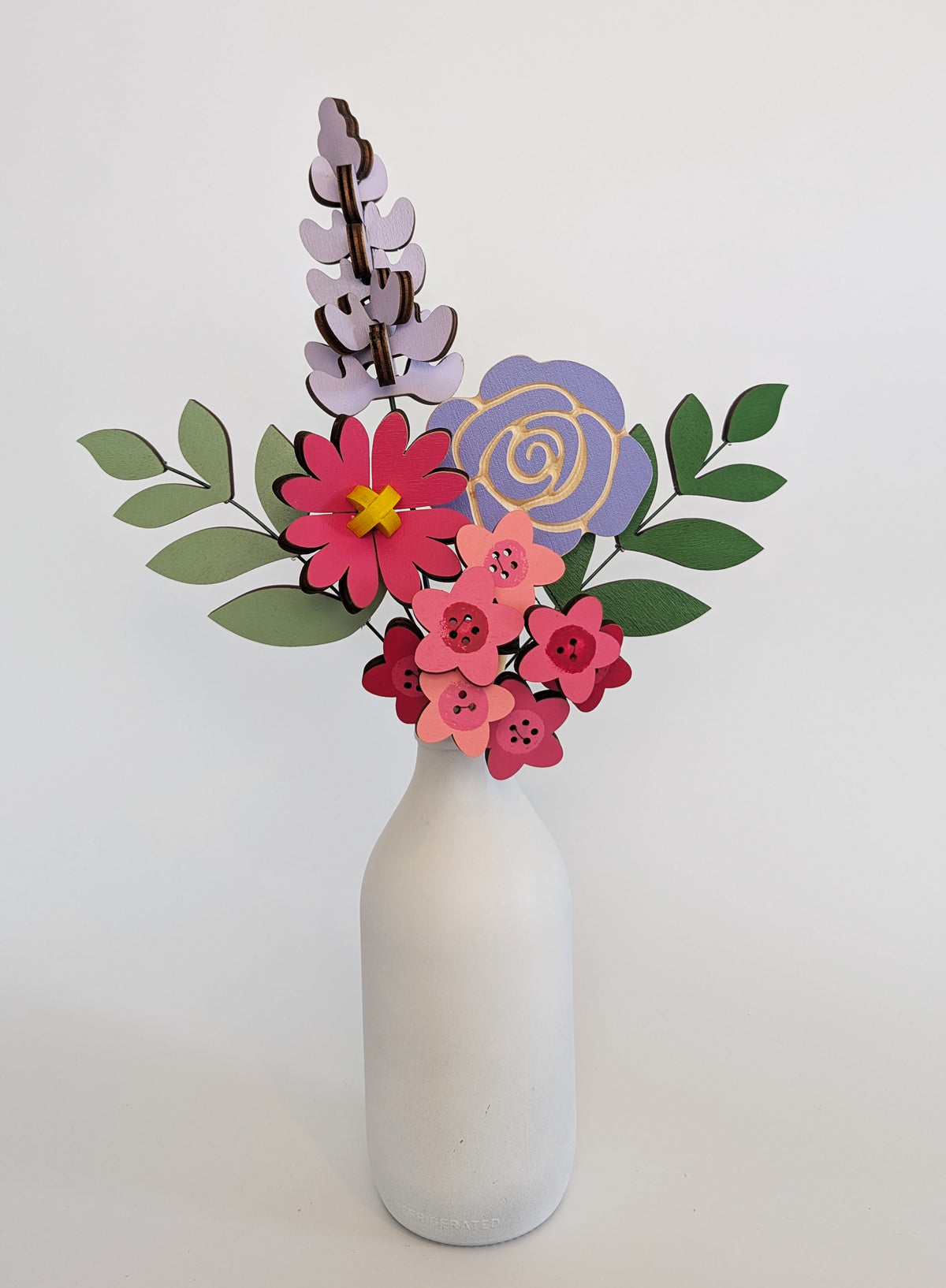 Signature Blooms in Macaron, four wooden blooms and two foliage stems in bright pink and violet, in a vase 