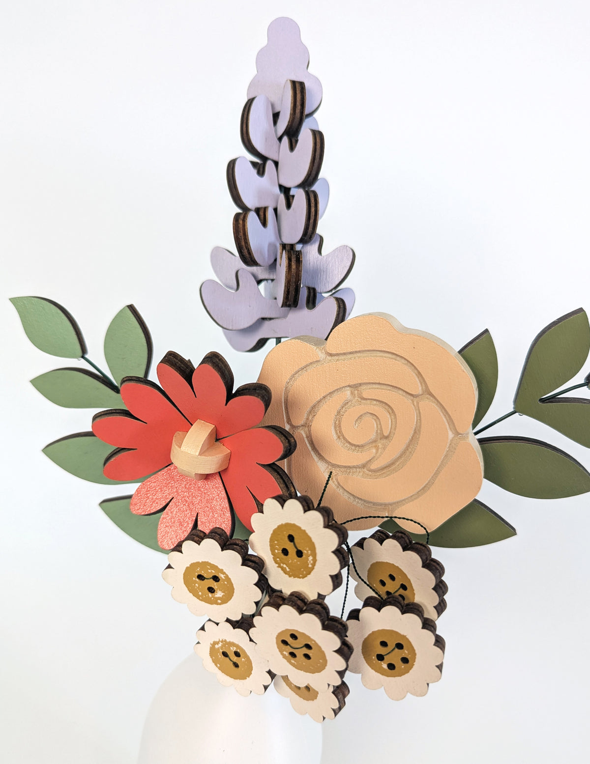 Signature Blooms in Sorbet, a close crop of the wooden blooms in muted mustard, lilac, peach, coral and sage 