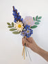 Signature Blooms in Parma Violet, four wooden blooms and two foliage stems in violet and lilac, held in one hand 